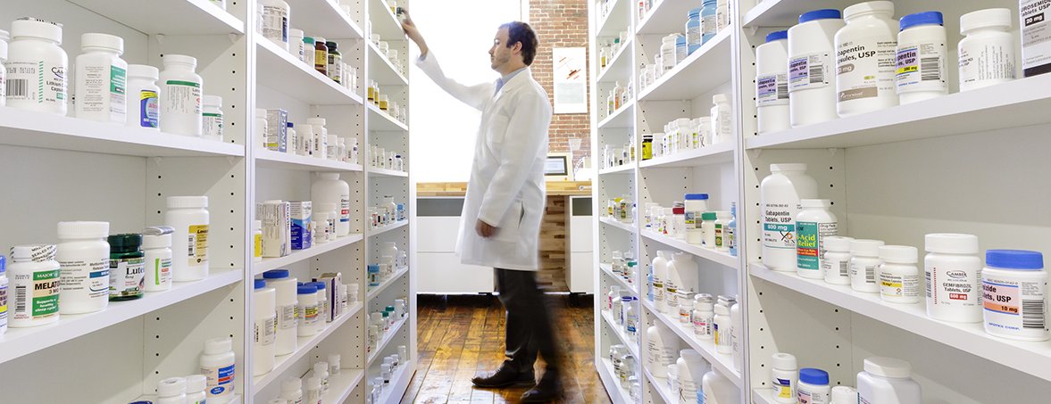 Organized shelves of labeled medication containers in a dispensing area